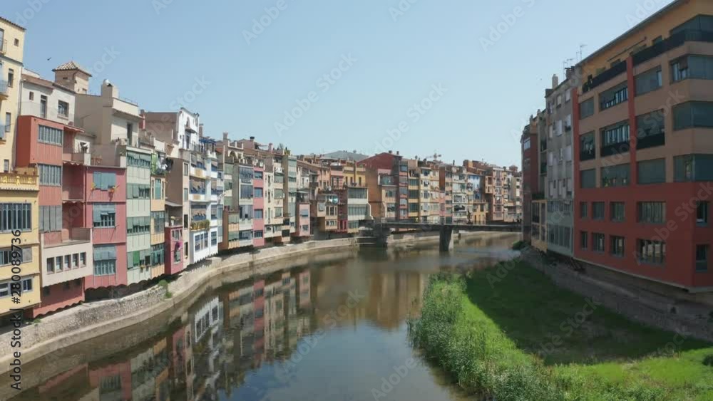 Aerial view of houses on river Onyar, Girona's main symbol. Drone shot of hanging houses or river houses of varying size and shape with facades of vivid colour Aerial view of houses on river Onyar, Girona's main symbol. Drone shot of hanging houses or river houses of varying size and shape with facades of vivid colour