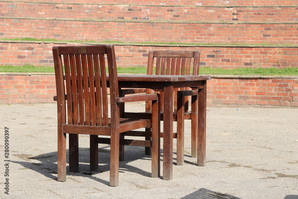 A wooden table and chairs in a brick amphitheater A wooden table and chairs in a brick amphitheater