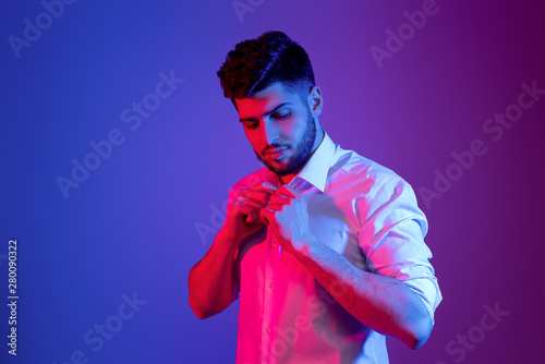 handsome bearded man in neon light posing
