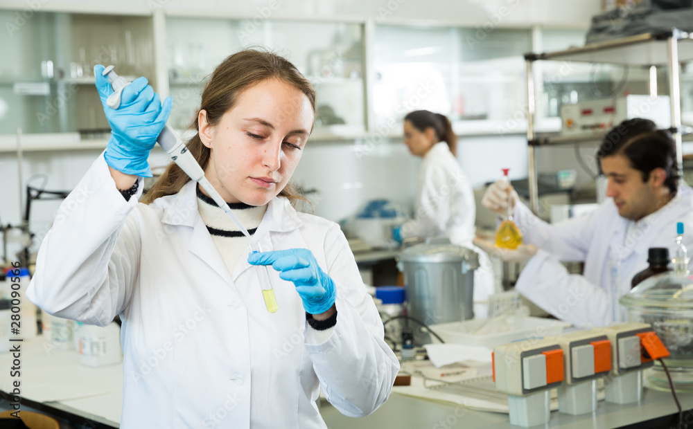 Fototapeta premium Female pipetting reagent in test tube