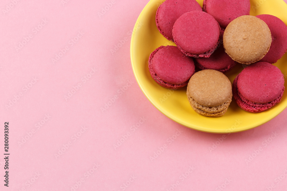 yellow plate with macaroons isolated on pink