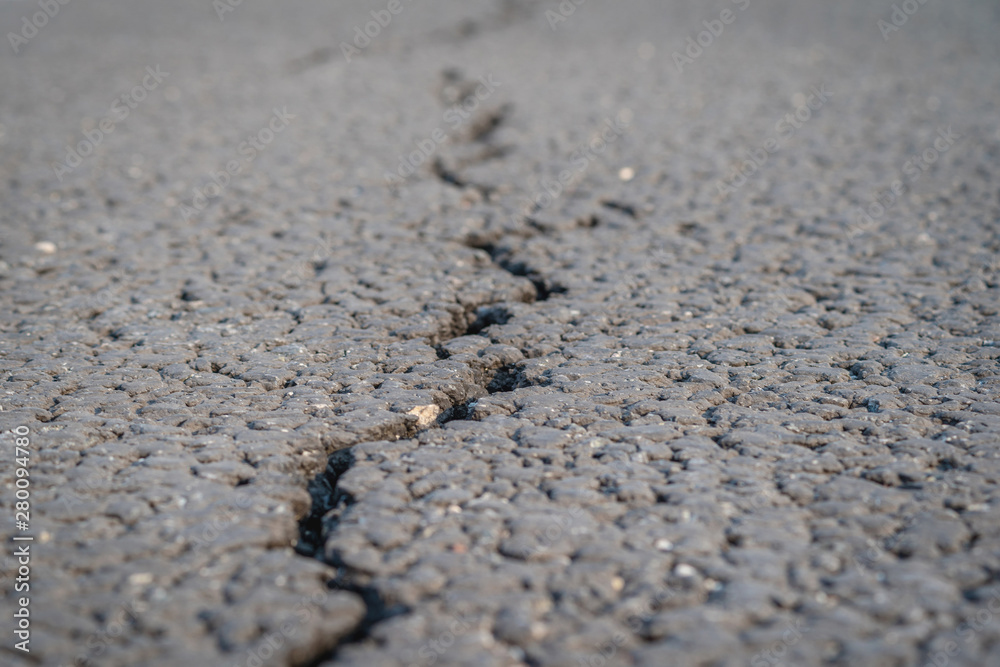 terrible crack in the road pavement, close up blurry background terrible crack in the road pavement, close up blurry background