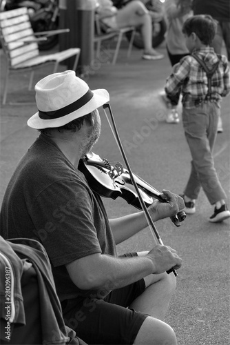 man in hat playing on bench in park