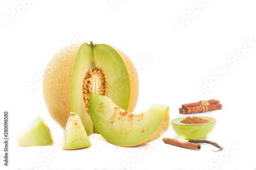 Cantaloupe melon and melon slices with cinnemon and brown sugar on white background. Refreshing slices of ripe, sweet melon. photo