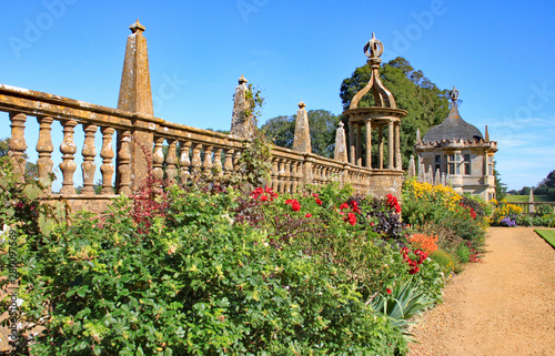Wall with ballustrades behind a flower bed at an english stately home near Yeovil in Somerset, England