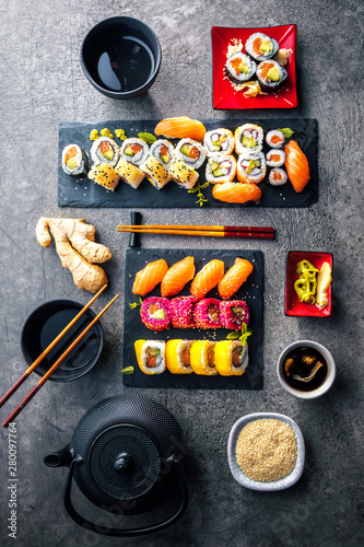 Sushi Set sashimi and sushi rolls served on stone slate