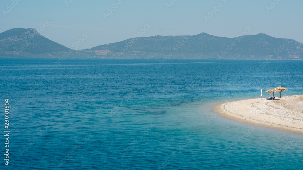 Empty beach in Greece with one sunshade