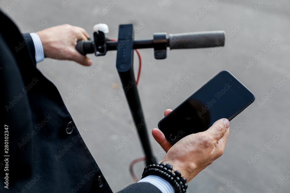 Close up image of a man on an electric scooter paying online