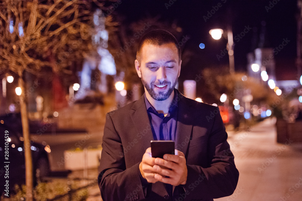 Young man using smart phone outdoor in the evening