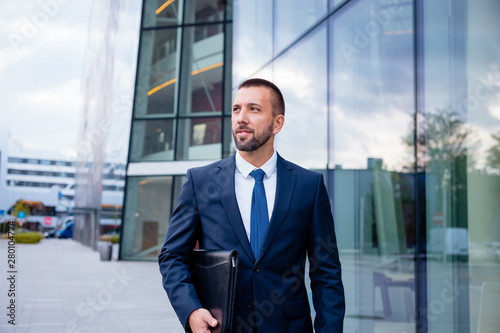 Young businessman standing in front modern office