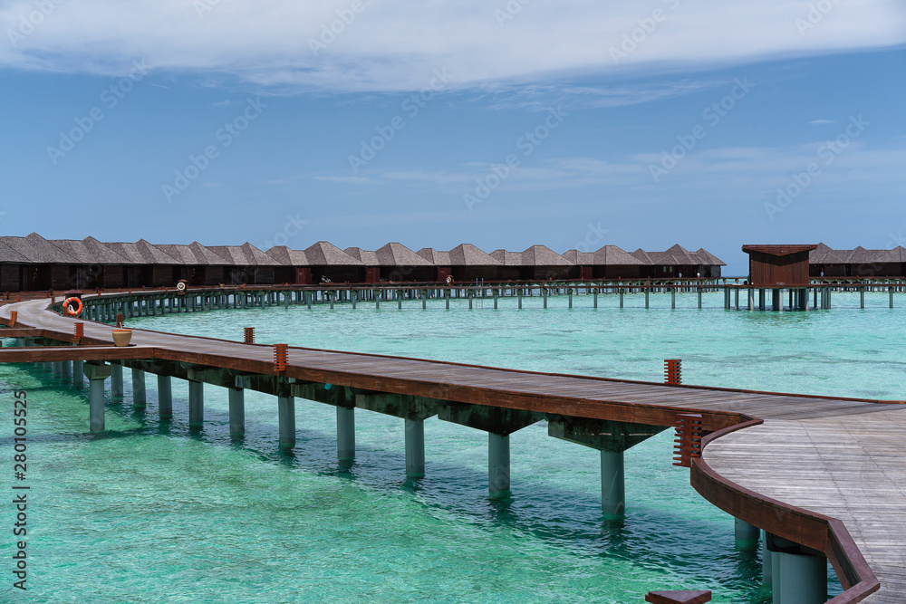 Water villas in Maldives in a sunny day, island paradise relax