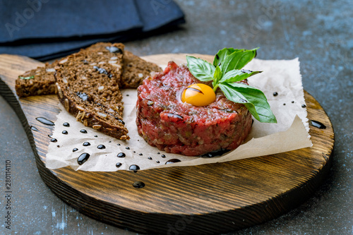 Tablou pe pânză Tartare from beef with egg on wooden background