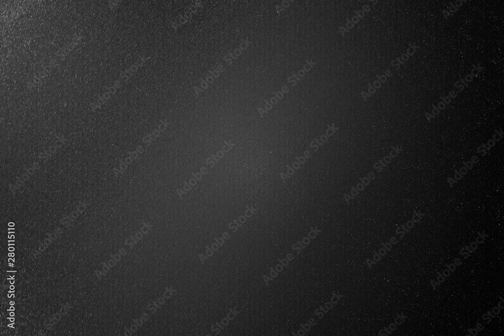 Dirty brushed black metal wall in dark room, abstract texture background