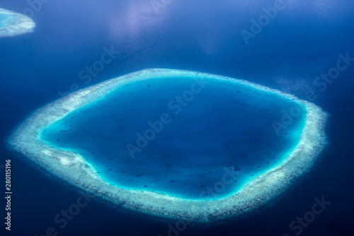 Dieses einzigartige Bild zeigt die Malediven, die von einem Flugzeug von oben fotografiert werden. Sie können die Atolle im Meer gut sehen. photo