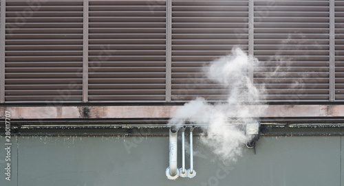 Smoke pipe from the building. Exhaust ventilation system with smoke coming out on side of building