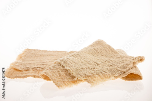 Beige cotton napkin, isolated on a white background