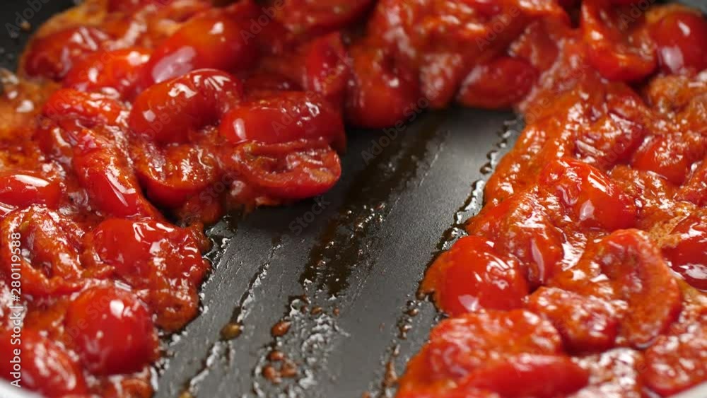 Close up shot of thick tomato sauce bubbling in hot pan, wooden spatula splitting sauce into two sides of pan Close up shot of thick tomato sauce bubbling in hot pan, wooden spatula splitting sauce into two sides of pan