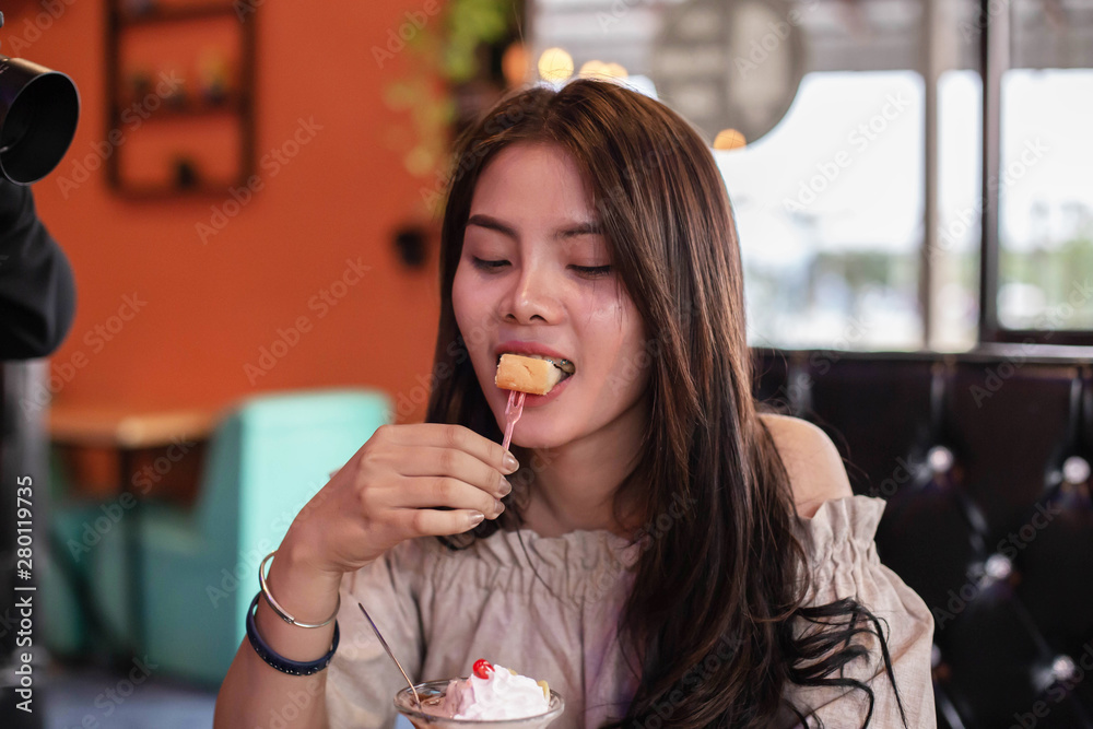 Beautiful girl sitting to eat ice cream in a restaurant Beautiful girl sitting to eat ice cream in a restaurant