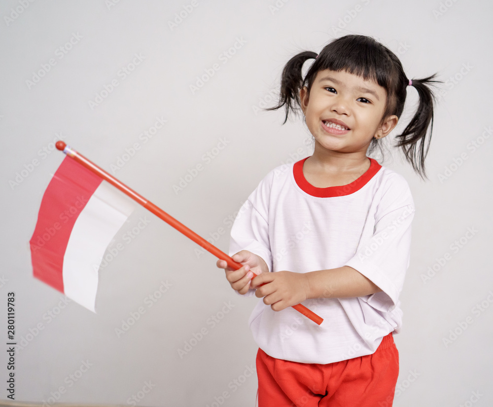 asian toddler with indonesian flag smiling to camera over white background asian toddler with indonesian flag smiling to camera over white background