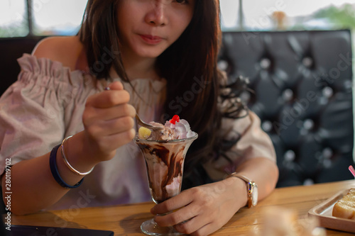 Beautiful girl sitting to eat ice cream in a restaurant