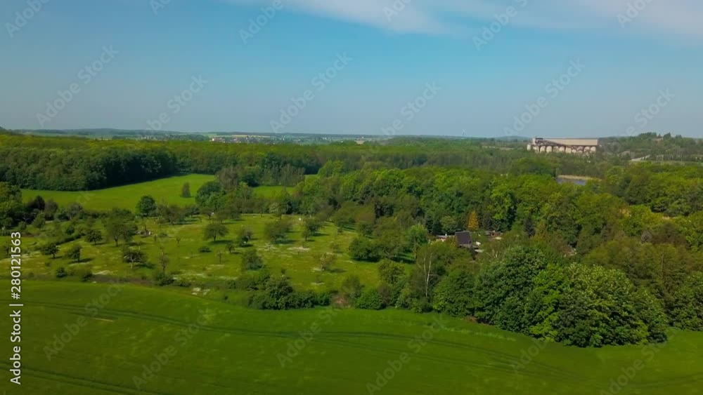 Aerial view of little village in between meadows and forest during spring or summer time Aerial view of little village in between meadows and forest during spring or summer time