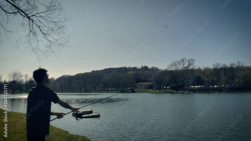 Man casting his line with bait into the water. Long fishing pole bends with the force of forward motion as line carries bait far out into a lake. Slow motion. Man casting his line with bait into the water. Long fishing pole bends with the force of forward motion as line carries bait far out into a lake. Slow motion.
