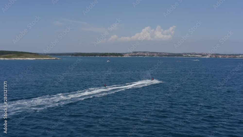 AERIAL of a jet ski pulling a man water skiing AERIAL of a jet ski pulling a man water skiing