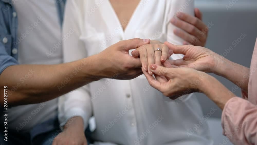 Man holding fiancee hand with engagement ring, showing to mother, happy family Man holding fiancee hand with engagement ring, showing to mother, happy family