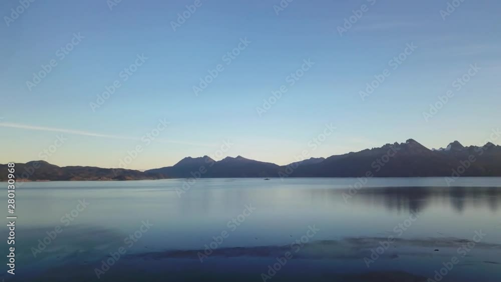 Drone aerial dolly forward beagle channel calm sunset and small boat sailing Drone aerial dolly forward beagle channel calm sunset and small boat sailing