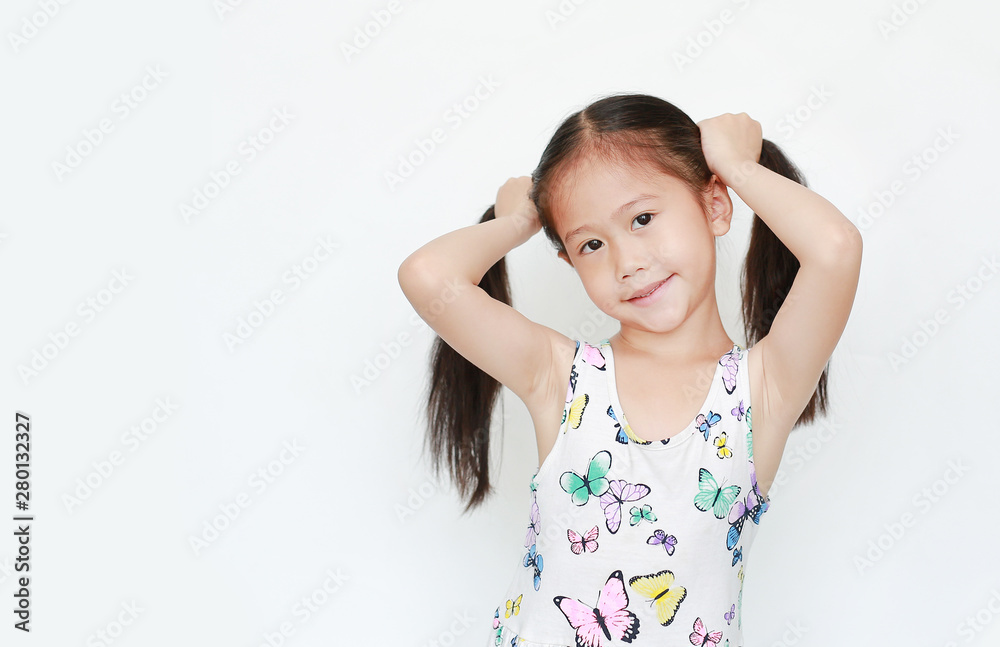 Beautiful little Asian child girl holding pigtail on white background. Portrait smiling children with two pigtails. Beautiful little Asian child girl holding pigtail on white background. Portrait smiling children with two pigtails.