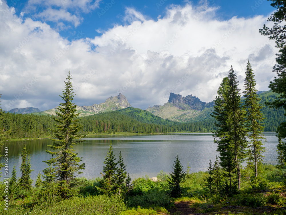 Mountains Ergaki Park. Lake Light. In the distance, you can see the peak of the bird and the peak of Star Mountains Ergaki Park. Lake Light. In the distance, you can see the peak of the bird and the peak of Star
