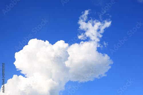 Blue sky background with puffy clouds.