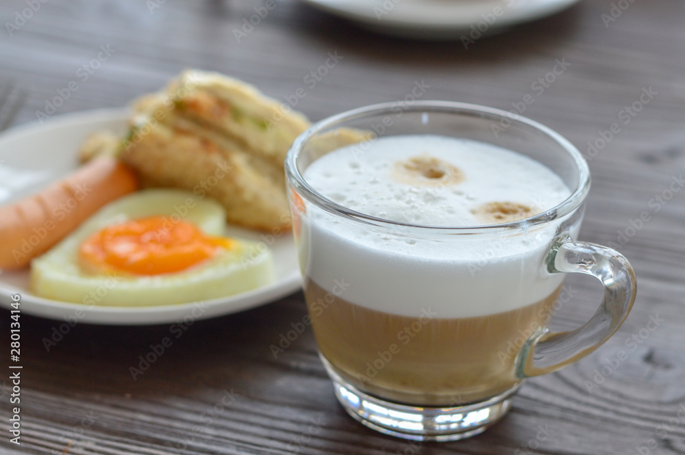 Selective focus cup of coffee on table and blur breakfast background. Selective focus cup of coffee on table and blur breakfast background.