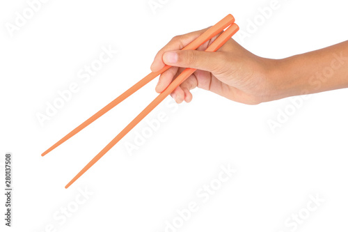  Women's hand holding orange plastic chopsticks isolated on white background.