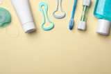 Flat lay composition with tongue cleaners and teeth care products on color background. Space for text