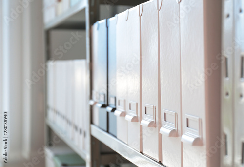 Folders with documents on shelf in archive