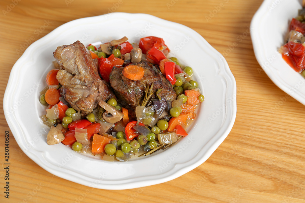 Plate with meat and garnish prepared in multi cooker on wooden table Plate with meat and garnish prepared in multi cooker on wooden table