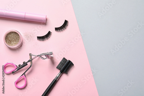 Fototapeta Naklejka Na Ścianę i Meble -  Flat lay composition with false eyelashes and other makeup products on color background, space for text