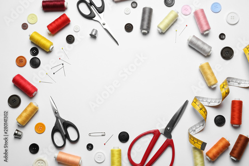 Frame made of scissors and other sewing accessories on white background, top view. Space for text