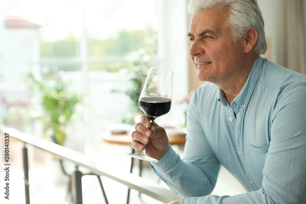 Senior man with glass of wine in restaurant. Space for text Senior man with glass of wine in restaurant. Space for text