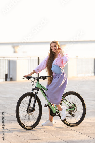 Young woman riding bicycle in city on sunny day