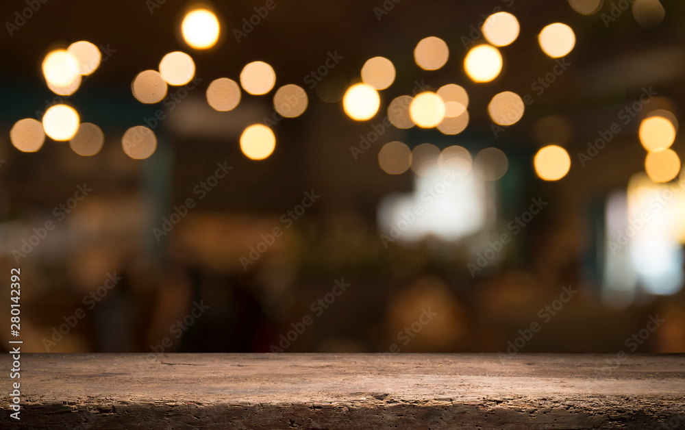 Empty wood table top on blur light gold bokeh of cafe restaurant in dark background Empty wood table top on blur light gold bokeh of cafe restaurant in dark background