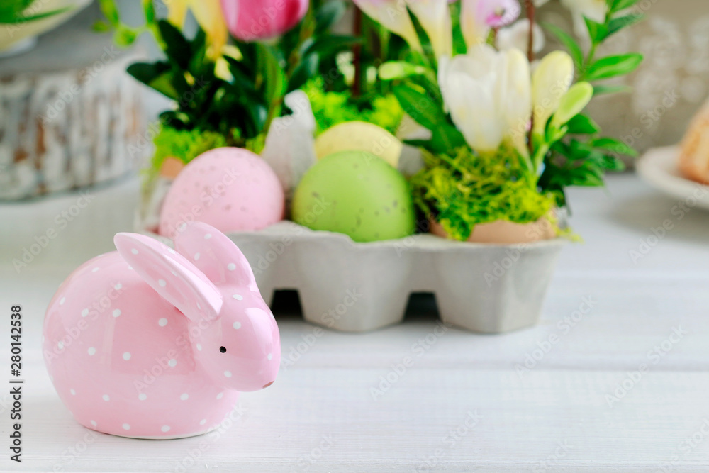 Dotted pink ceramic rabbit and floral decoration in the background. Dotted pink ceramic rabbit and floral decoration in the background.