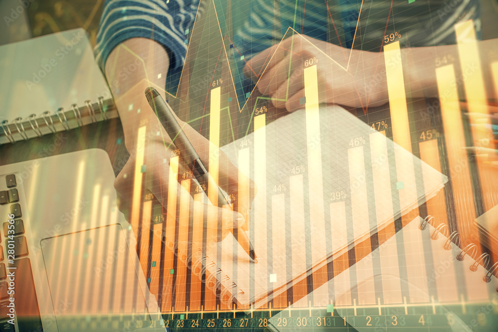 Fototapeta premium Financial chart drawn over hands taking notes background. Concept of research. Double exposure