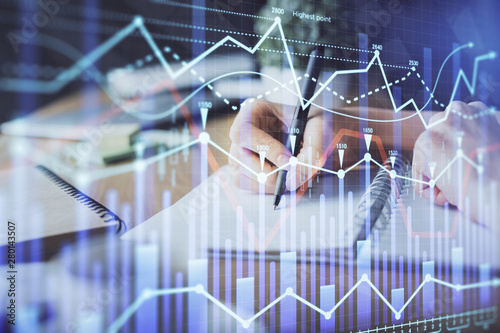 Financial forex graph drawn over hands taking notes background. Concept of research. Multi exposure