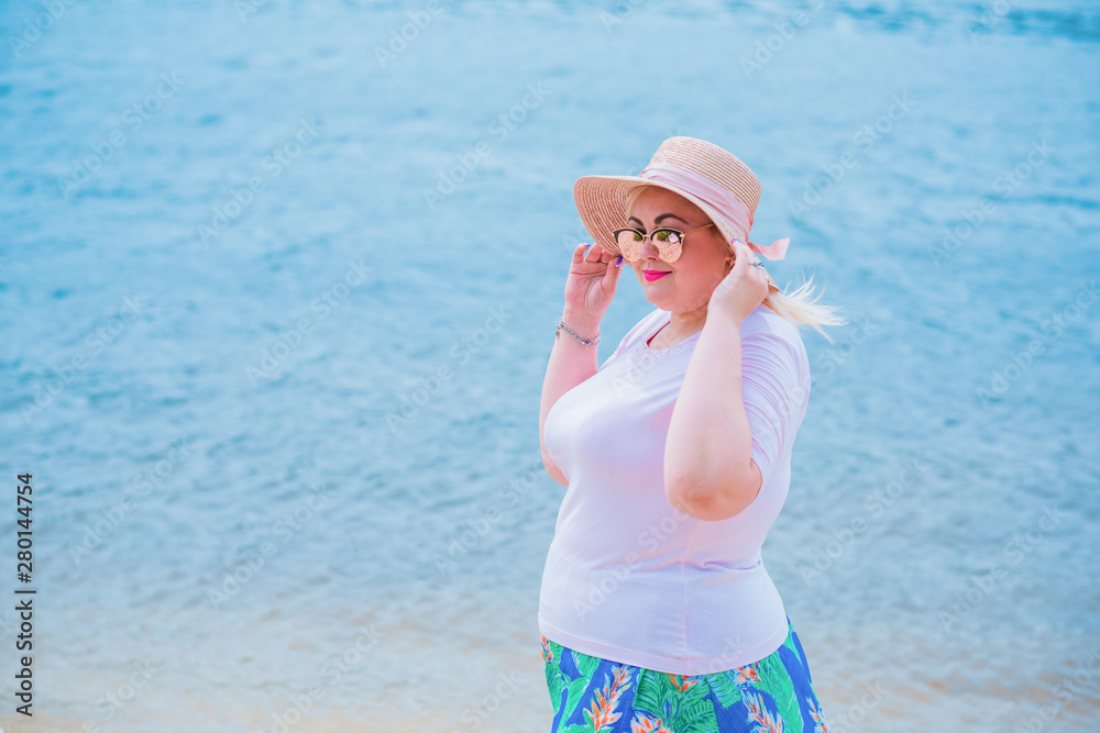 Nice European or American plump girl at beach in straw hat, concept of modern woman lifestyle, walk near water Nice European or American plump girl at beach in straw hat, concept of modern woman lifestyle, walk near water