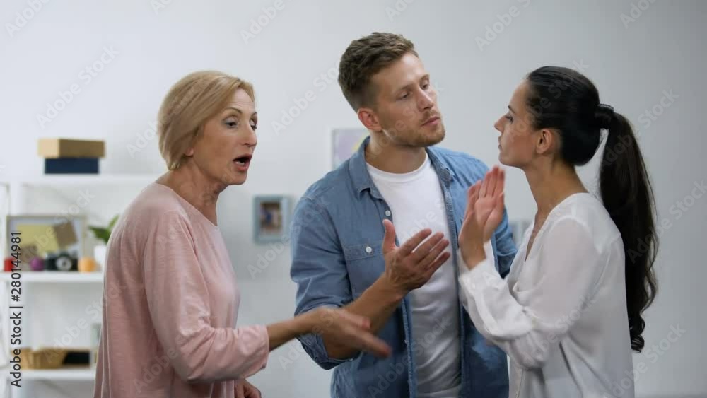 Young man settling conflict between mother and wife, family problems, quarrel