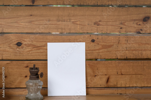 Woman holding paper blank of drawing paper paper with wooden background.
