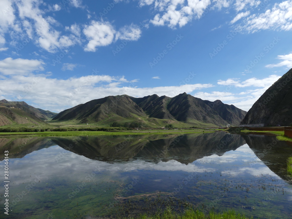 Beautiful landscape in western China Mountains clouds blue sky and mirroring christal clear lake