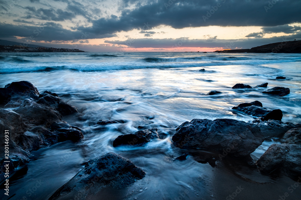 Obraz premium Wild sunset at the beach in winter season. Artistic landscape with sun and sea water. Beautiful concept of travel and adventure alternative vacation. Colors and background with water